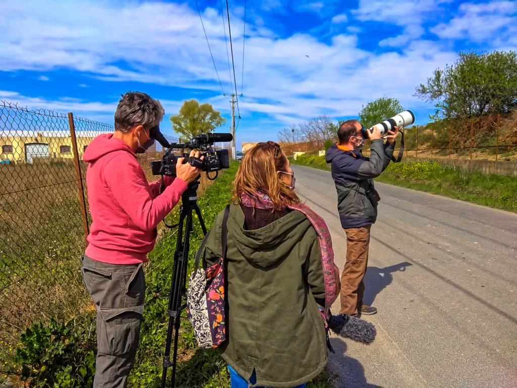 Équipe de tournage et photographe au téléobjectif au bord d’une route